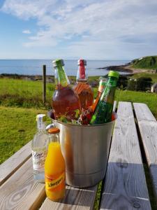 a bucket full of beer bottles on a picnic table at Dunbeath Coastal Retreat in Dunbeath