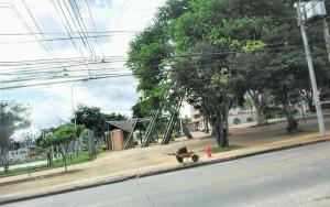 a person sitting on a bench on a sidewalk next to a fire hydrant at Rincon de ensueño in Santa Cruz de la Sierra