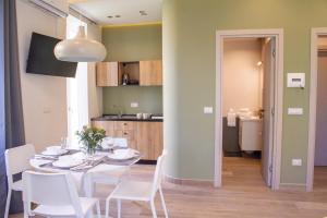 a dining room with a white table and white chairs at Sirena Partenope e San Gennaro HOME - Rione Sanità - Centro Storico Napoli in Naples