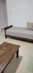 2 camas y una mesa de madera en una habitación en Depto en Tandil Garibaldi 388 en Tandil