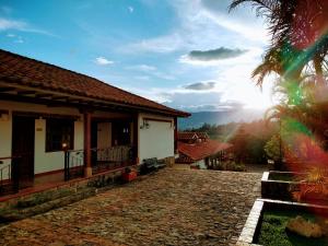 a house with a stone pathway next to a building at Hotel Bosque de la Villa in Villa de Leyva