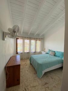 Schlafzimmer mit einem Bett, einem Tisch und Fenstern in der Unterkunft Río Mar Cumayasa in La Romana