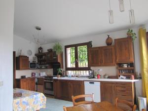 eine Küche mit Holzschränken, einem Tisch und einem Fenster in der Unterkunft Villa confort, vue d'exeption, montagne, jardin in Crest