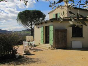 a small house with green doors and a table at Villa confort, vue d'exeption, montagne, jardin in Crest