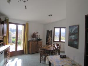 uma cozinha e sala de jantar com mesa e cadeiras em Villa confort, vue d'exeption, montagne, jardin em Crest