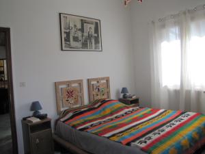 um quarto com uma cama com um cobertor colorido em Villa confort, vue d'exeption, montagne, jardin em Crest