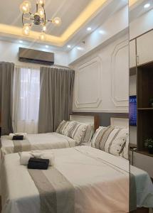 馬尼拉的住宿－Resort Style Condo Walkable to Mall of Asia，一间带两张床的卧室和一台电视