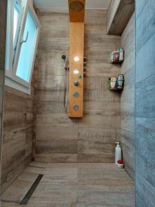 a bathroom with a shower with a wooden wall at Family apartment Andrea in Alaquas