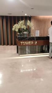 マニラにあるResort Style Condo Walkable to Mall of Asiaの花のテーブルの前に立つ男