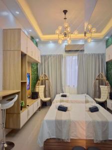 マニラにあるResort Style Condo Walkable to Mall of Asiaのベッドルーム1室(ベッド2台、椅子2脚付)