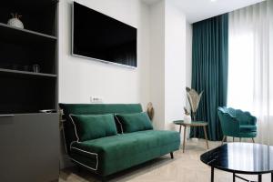 a living room with a green couch and a tv at Salotto Room Boutique in Pescara