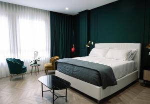 a bedroom with a large bed and a green wall at Salotto Room Boutique in Pescara