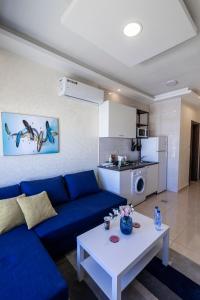een woonkamer met een blauwe bank en een witte tafel bij Jubeiha View Apartments in Amman