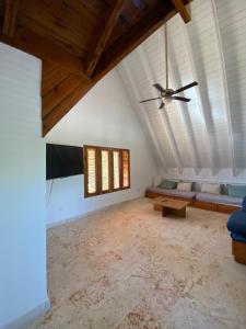 ein Wohnzimmer mit einem Deckenventilator und einem Sofa in der Unterkunft Río Mar Cumayasa in La Romana
