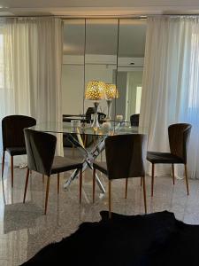 a dining room with a glass table and chairs at Koliba apartments in Bratislava