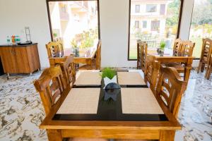uma sala de jantar com uma mesa de madeira e cadeiras em Xomotel Blue River em Belparāo