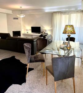 a living room with a glass table and a piano at Koliba apartments in Bratislava