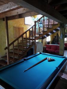 una mesa de billar en una sala de estar con una escalera en El Escondite del Miera en San Roque de Ríomiera