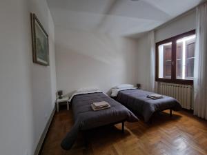 1 dormitorio con 2 camas y ventana en I Bócci, en Castel dʼAiano