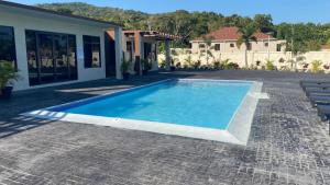una piscina frente a una casa en The Roseville en Ocho Rios