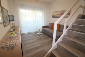 sala de estar con escalera y sofá en Residence Isvico, en Lignano Sabbiadoro