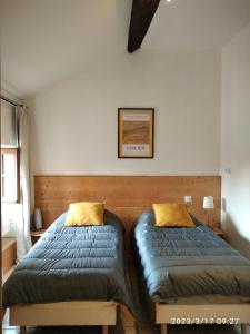- une chambre avec 2 lits et une photo sur le mur dans l'établissement Le Grenier Maufoux, à Beaune