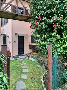 a house with a garden with a bush with roses at Villa Giardino con pontile sul Lago D’Orta in riva in Orta San Giulio