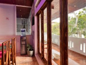 um quarto com paredes roxas e uma cozinha com uma janela em The Lovina Place em Watumulla