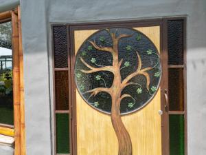 una puerta con un árbol pintado en ella en El Frijolito Mágico LODGE, en Tabio
