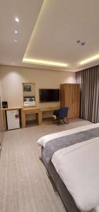 a hotel room with a bed and a flat screen tv at شقق ظلال النخيل in Al Khobar