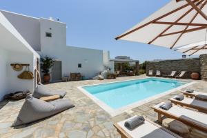 a villa with a swimming pool and patio furniture at VILLA NOSTOS ANTIPAROS in Antiparos