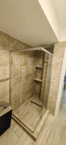 a glass shower in a room with a wooden floor at Apartament 1 Mai bloc nou-Self check-in in Craiova