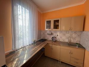 cocina con encimera de madera y ventana en Tiflisi Hostel, en Tiflis