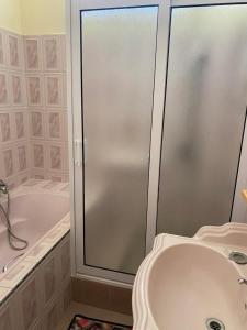 弗利康弗拉克的住宿－Shero Villa，带淋浴、盥洗盆和浴缸的浴室