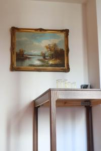 une peinture accrochée au mur avec une table en bois dans l'établissement Cozy & Charming City Apartment, à Vienne