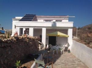 Casa blanca con mesa y sombrilla amarilla en Traditional Spanish cave house in Alguena, en Algueña