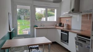cocina con encimera, mesa y 2 ventanas en Entre Nausicaa et Wimereux, en Boulogne-sur-Mer