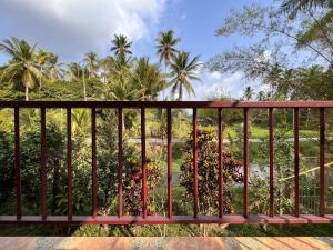 a balcony with palm trees in the background at Naisang Hostel in Chumphon