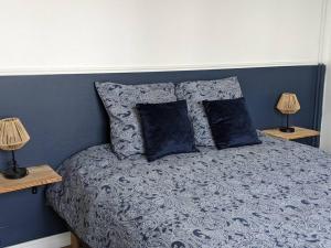 a bedroom with a bed with blue walls and two lamps at L'Effet-Mer in Dunkerque