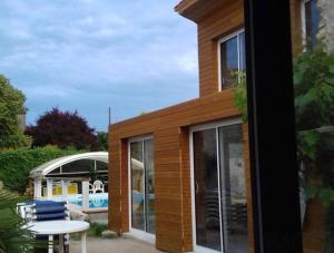 een huis met grote glazen ramen en een tafel bij Grande maison de famille avec piscine couverte in Nieulle-sur-Seudre
