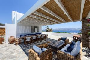an outdoor patio with a table and chairs and a bar at VILLA NOSTOS ANTIPAROS in Antiparos