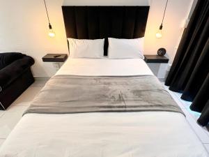 a bedroom with a large white bed with a black headboard at Industrial CHIC Apartment 113 - Luxury City Escape, Washing Machine & Fast WiFi in Johannesburg +51 photos