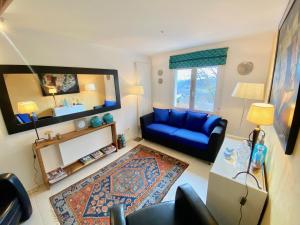 ein Wohnzimmer mit einem blauen Sofa und einem Spiegel in der Unterkunft Maisonnette la Grue - Vallée de la Dordogne in Aubazines