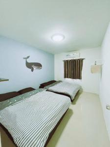 sypialnia z dwoma łóżkami w pokoju w obiekcie Pool Villa Sattahip White House w mieście Ban Tao Than