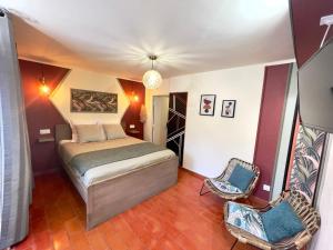1 dormitorio con 1 cama y 2 sillas en Mas des Coccinelles, en Mollans-sur-Ouvèze