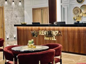 a hotel lobby with a reception desk and a table and chairs at Reggenza Hotel Downtown Ramallah in Ramallah