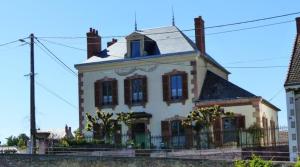Una gran casa blanca con una ventana en la parte superior. en Aux baboteurs GDF, en Vallon-en-Sully