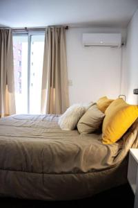 1 dormitorio con cama con almohadas y ventana en Fancy City Center Apt- Best Location in Cba en Córdoba