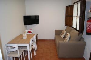una pequeña sala de estar con mesa y sofá en Apartamentos Camin De Pelayo, en Las Rozas