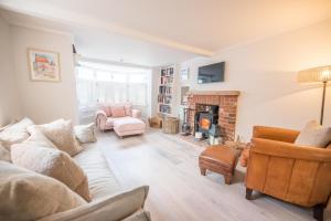 a living room with a couch and a fireplace at The Way Southwold in Southwold